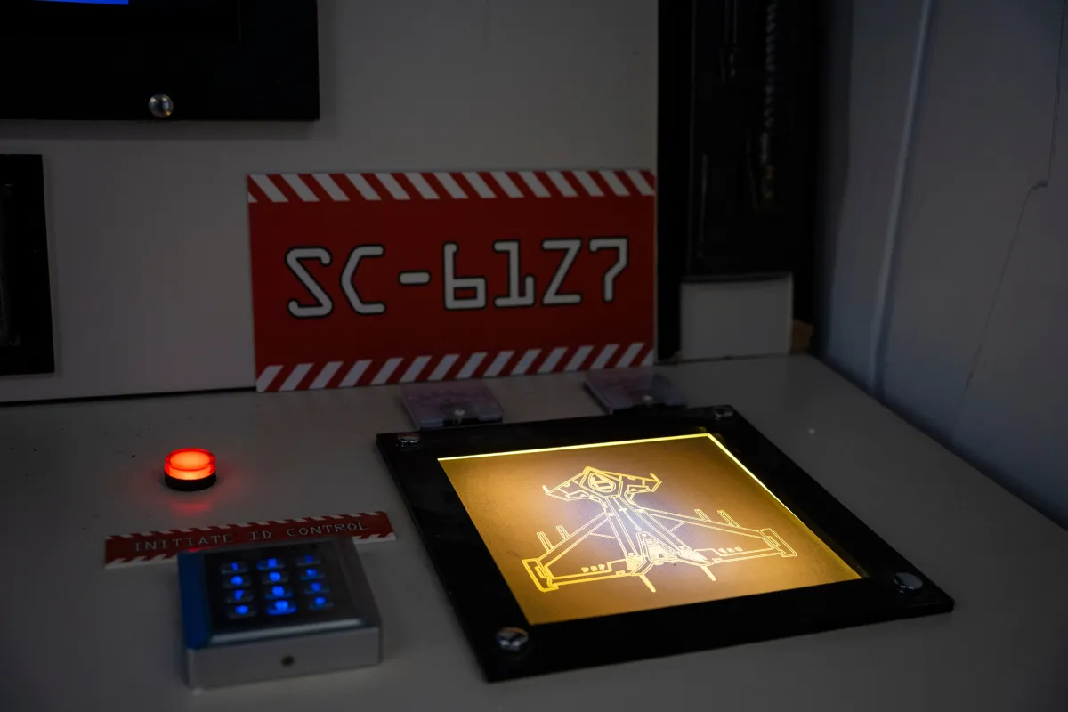Leuchtendes Display mit futuristischem Raumschiffentwurf, Ziffernblock und rotem Knopf