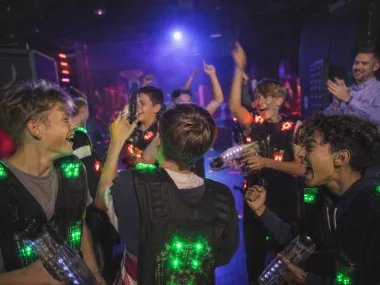 Schulklasse jubelt nach einer Lasertag-Runde (KI-Bild)